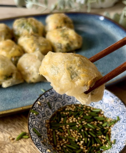 Food sticks holding rice dumpling over soucer with soy souce 