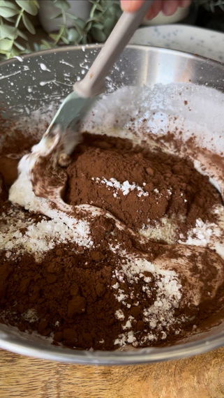 Adding coca powder and sugar to puffed egg whites