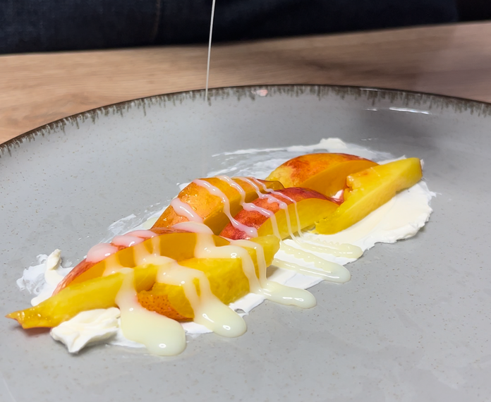 Pouring condenced milk onto peach